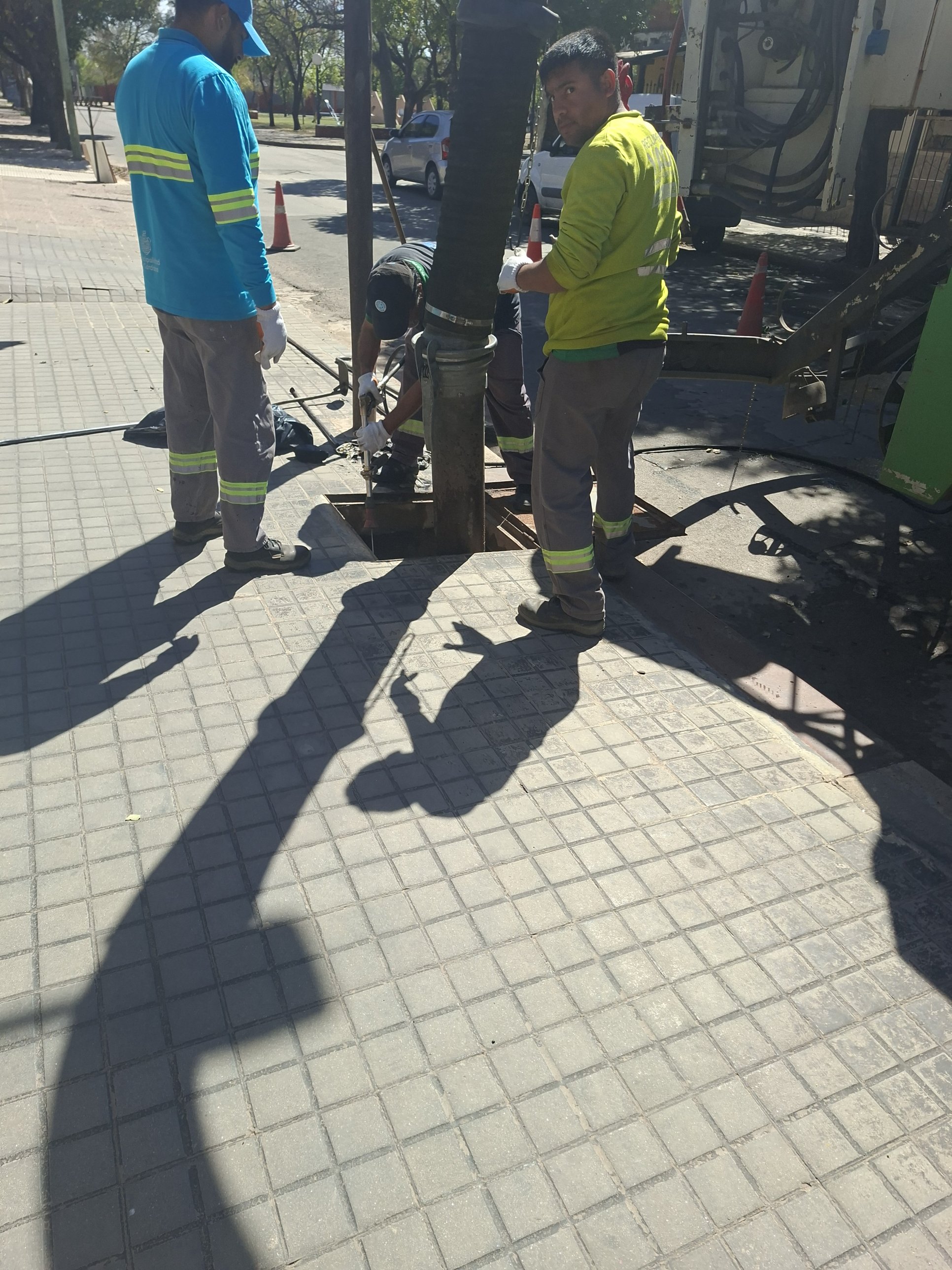 Cuadrilla realizando tareas de limpieza de la boca de tormenta con manguera