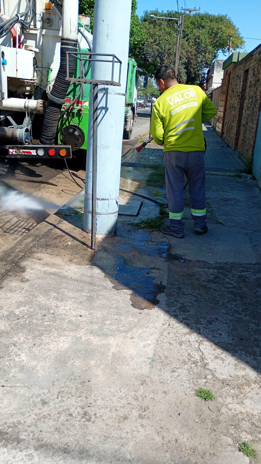 Operario realizando tareas de limpieza con hidrolavado en la vereda