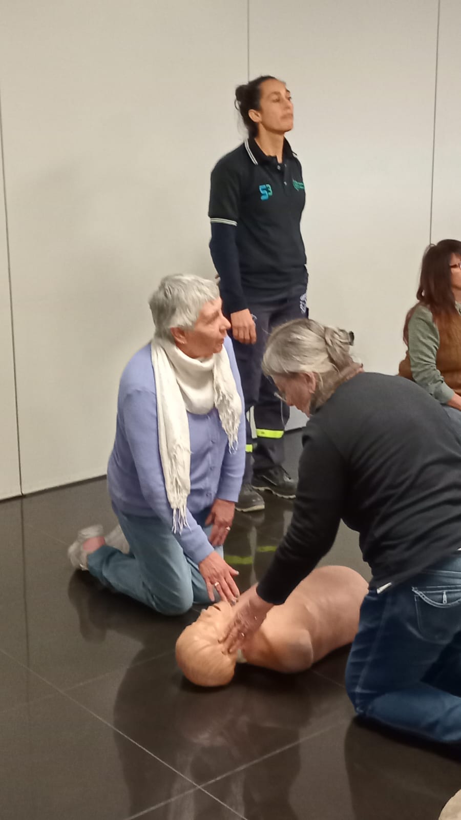 Práctica de reanimación cardiopulmonar sobre maniquí de entrenamiento, con instructora especializada